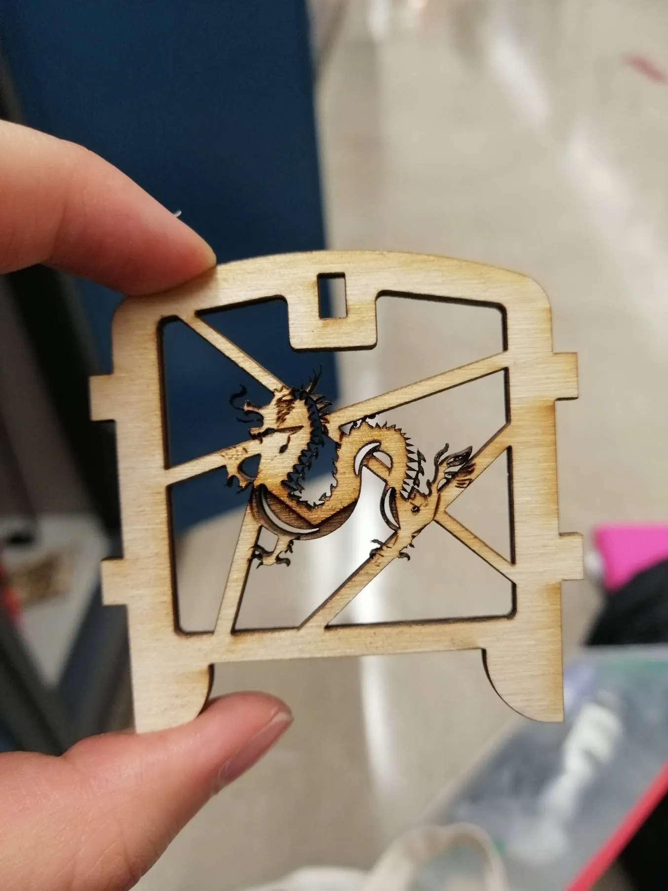 A hand holding a lasercut wooden mechanism